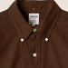 Close-up of a brown Kamakura Classics button-down shirt collar with white buttons and a visible brand label.