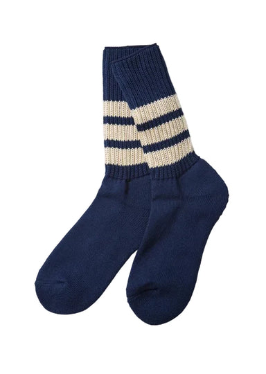 A pair of navy blue knit crew socks with two cream stripes near the cuff, displayed on a light gray background.