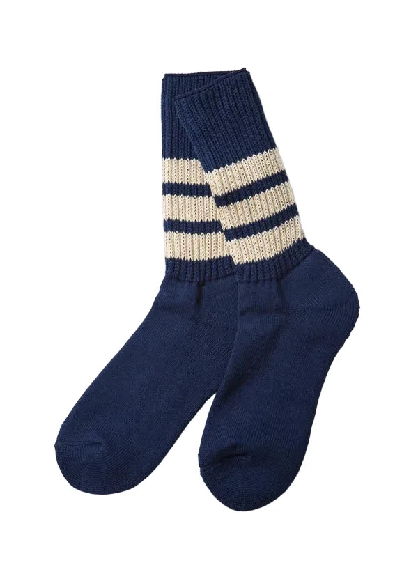 A pair of navy blue knit crew socks with two cream stripes near the cuff, displayed on a light gray background.