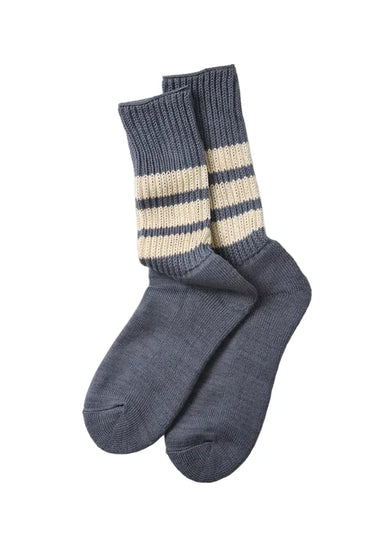 A pair of gray knit crew socks with two horizontal cream stripes near the ribbed cuffs, displayed on a light gray background.