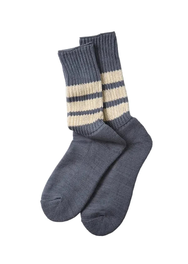 A pair of gray knit crew socks with two horizontal cream stripes near the ribbed cuffs, displayed on a light gray background.
