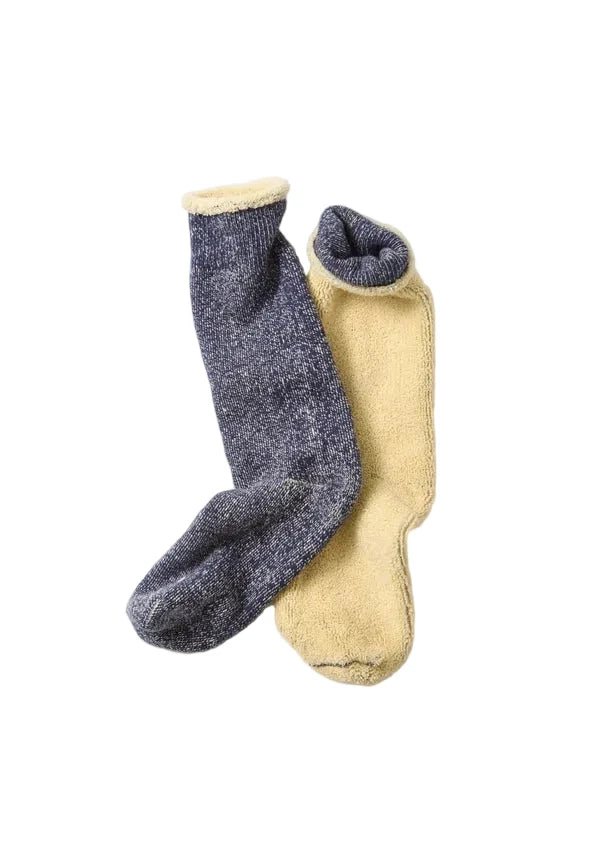 Two pairs of cozy crew socks, one in heathered dark gray and the other in soft mustard yellow, both featuring plush fleece lining and ribbed knit cuffs, displayed on a clean light gray background.