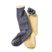 Two pairs of cozy crew socks, one in heathered dark gray and the other in soft mustard yellow, both featuring plush fleece lining and ribbed knit cuffs, displayed on a clean light gray background.