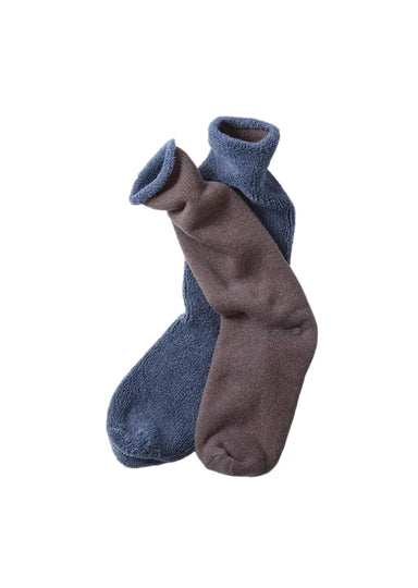 Two plush crew socks, one in dusty blue and one in taupe-brown, arranged overlapping on a clean white background.