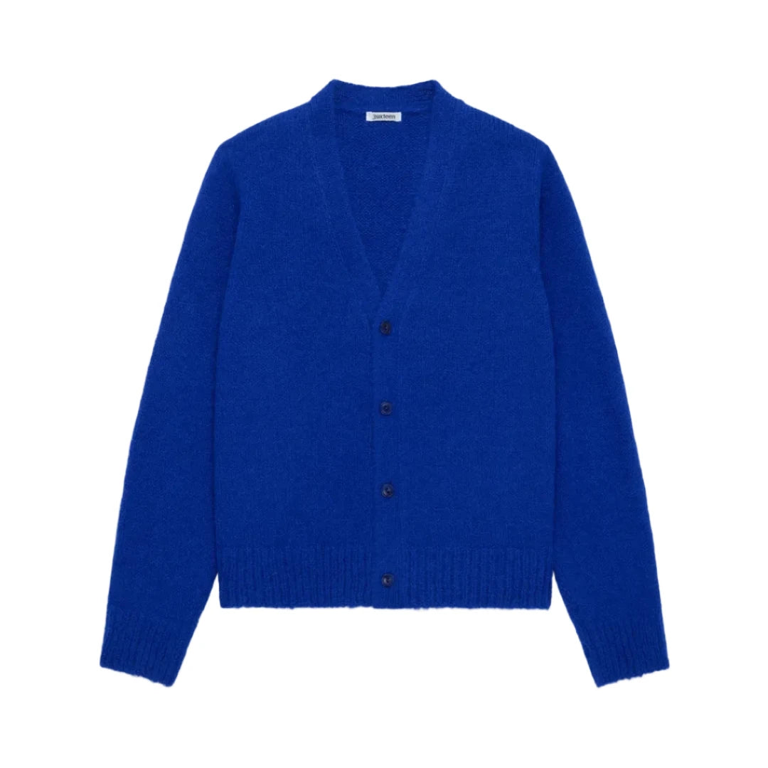 A vibrant royal blue knit cardigan sweater with a V-neck, button-front closure, and ribbed hem and cuffs, displayed on a clean light gray background.