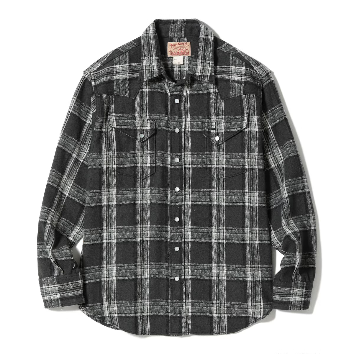 A long-sleeve plaid button-up shirt in black and white, laid flat against a white background. The shirt features a classic plaid pattern with two buttoned chest pockets and a collar label.