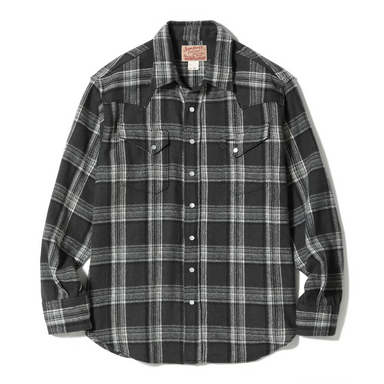 A long-sleeve plaid button-up shirt in black and white, laid flat against a white background. The shirt features a classic plaid pattern with two buttoned chest pockets and a collar label.