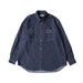 A dark indigo denim long-sleeve button-up shirt with two chest pockets, laid flat against a light cream background.