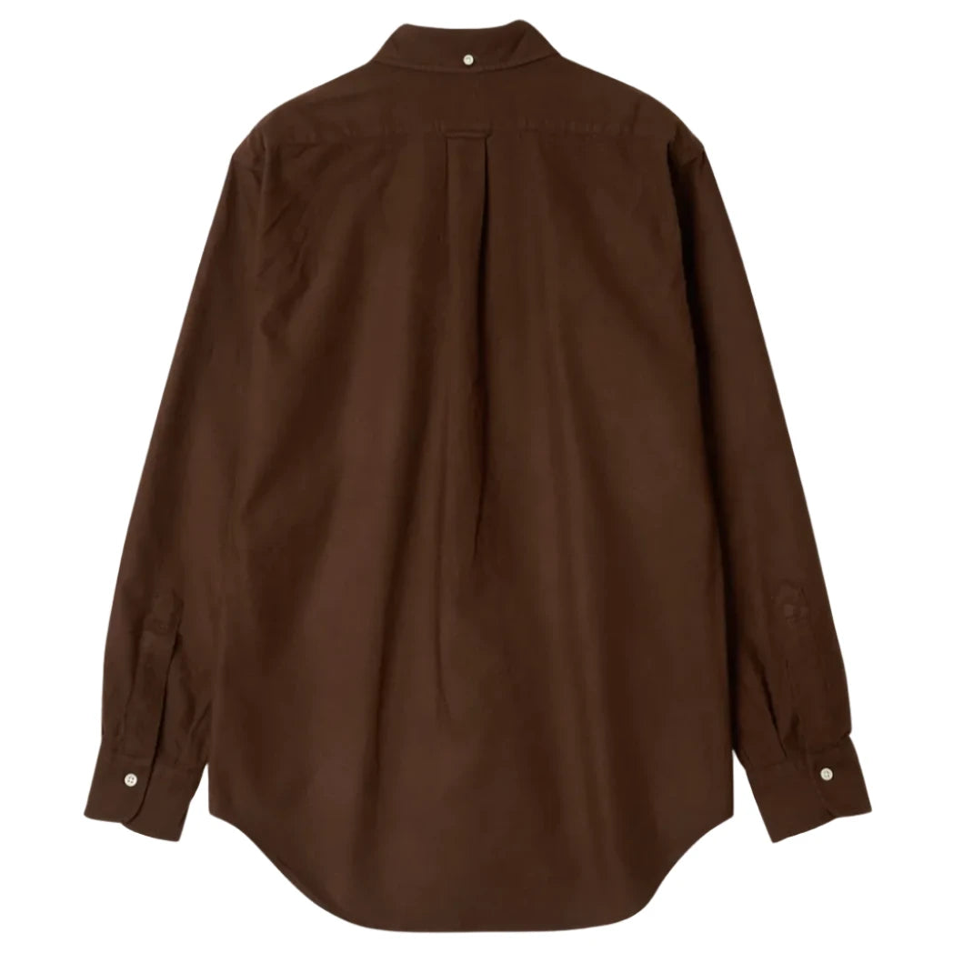 A dark brown long-sleeve button-up shirt shown from the back, featuring a central pleat and buttoned cuffs, laid flat against a solid light beige background.