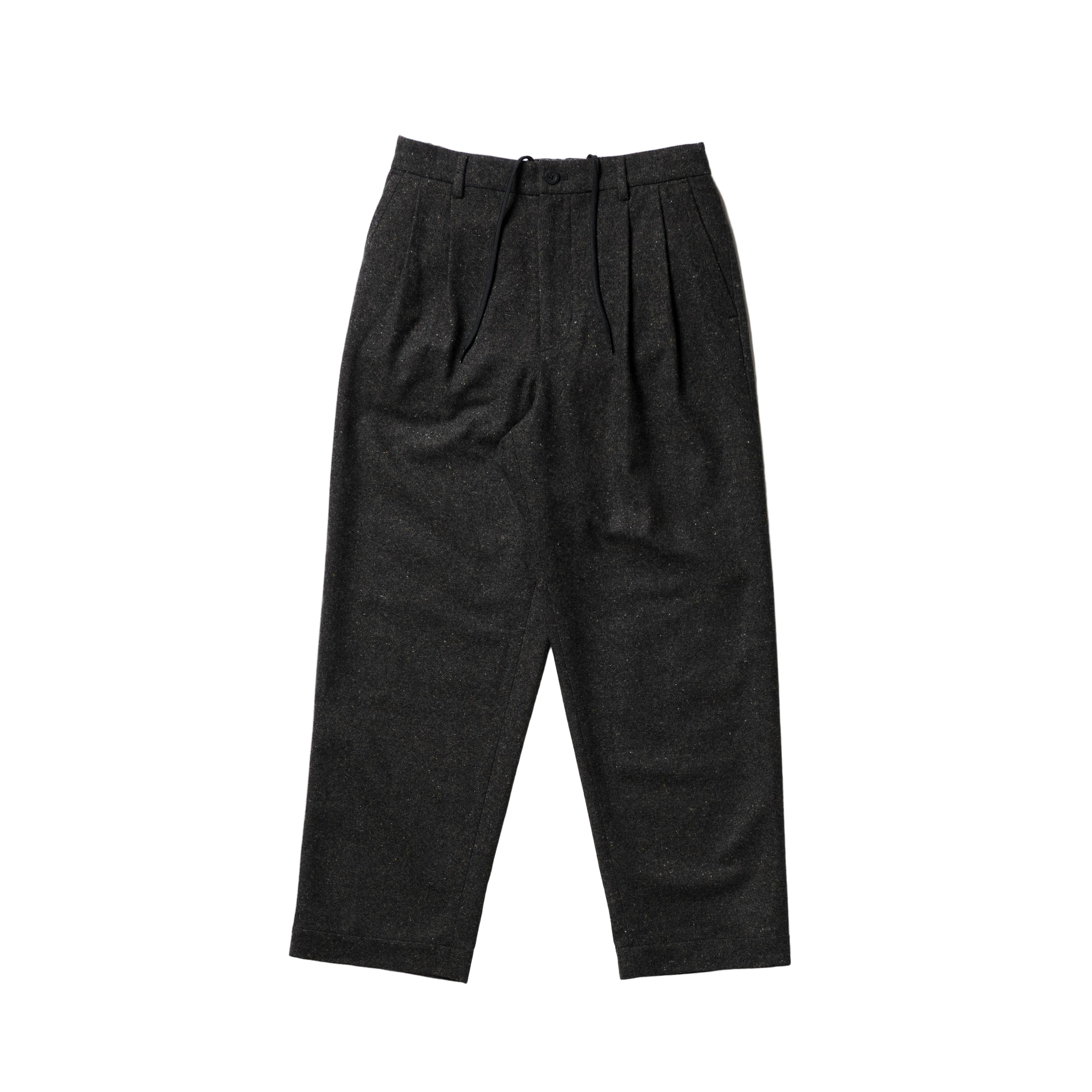 A pair of dark charcoal gray pleated wool trousers laid flat against a clean white background.
