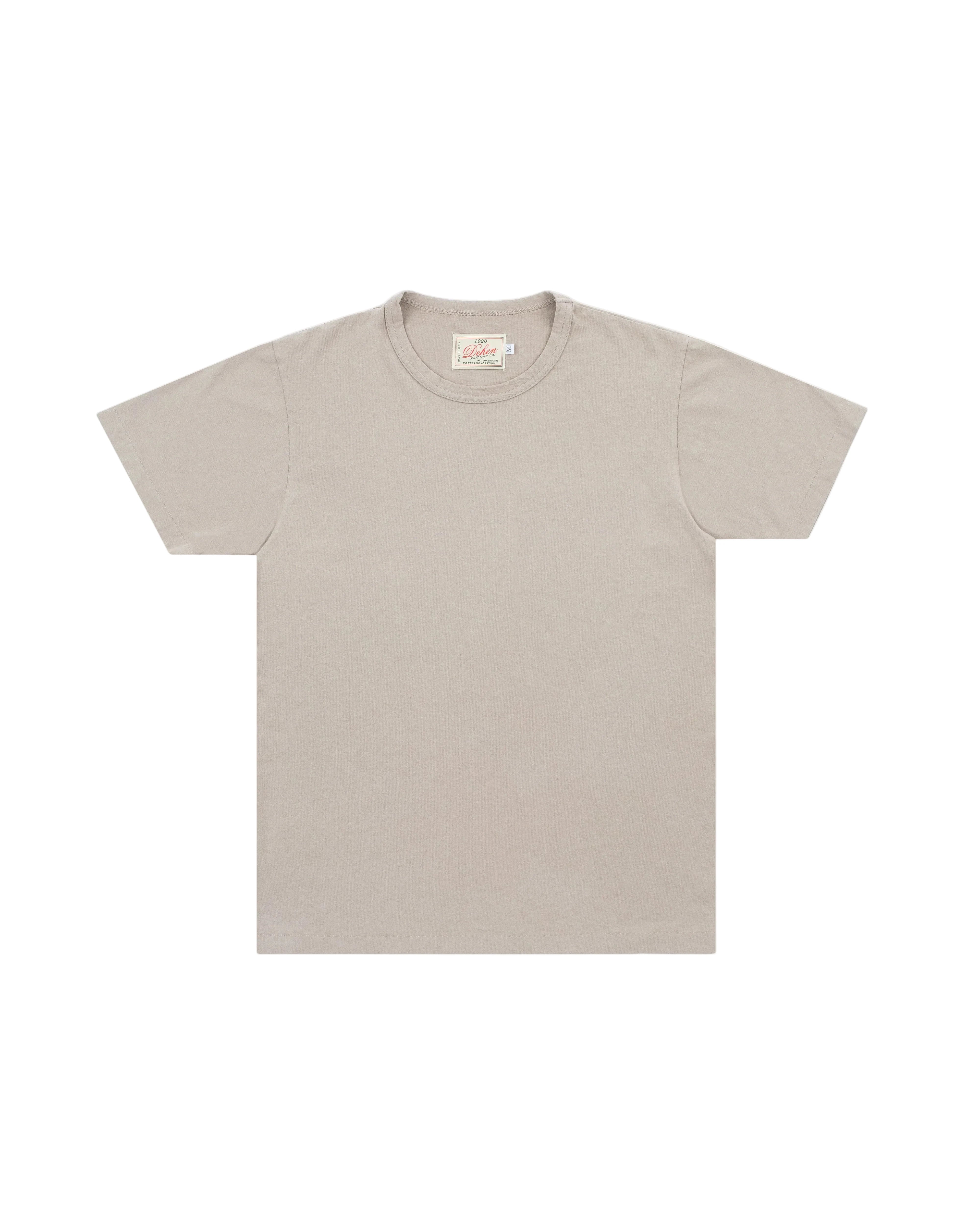 A light beige crewneck t-shirt with short sleeves, laid flat against a light gray background.