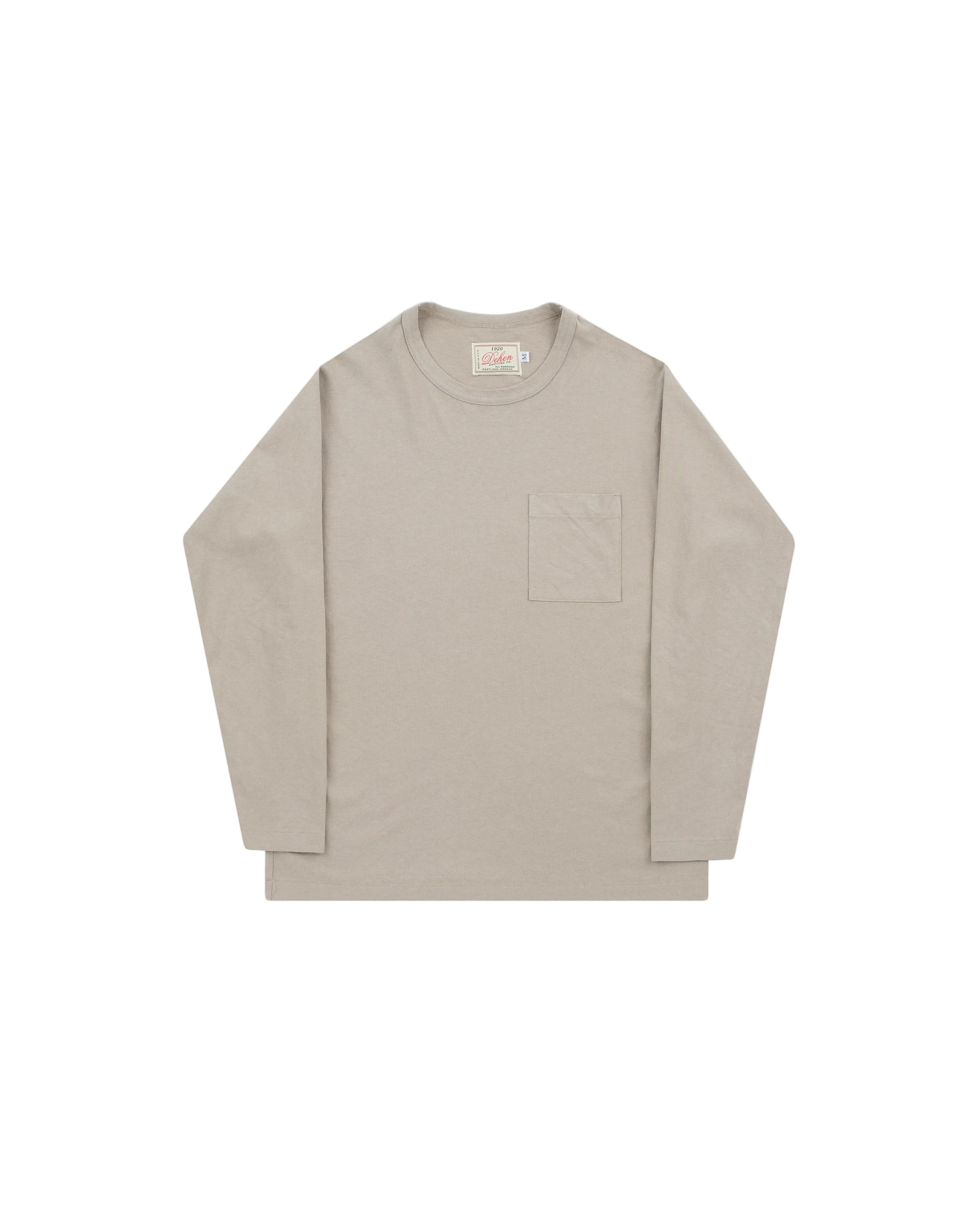 A light beige long-sleeve crewneck shirt with a single chest pocket, laid flat against a light gray background.