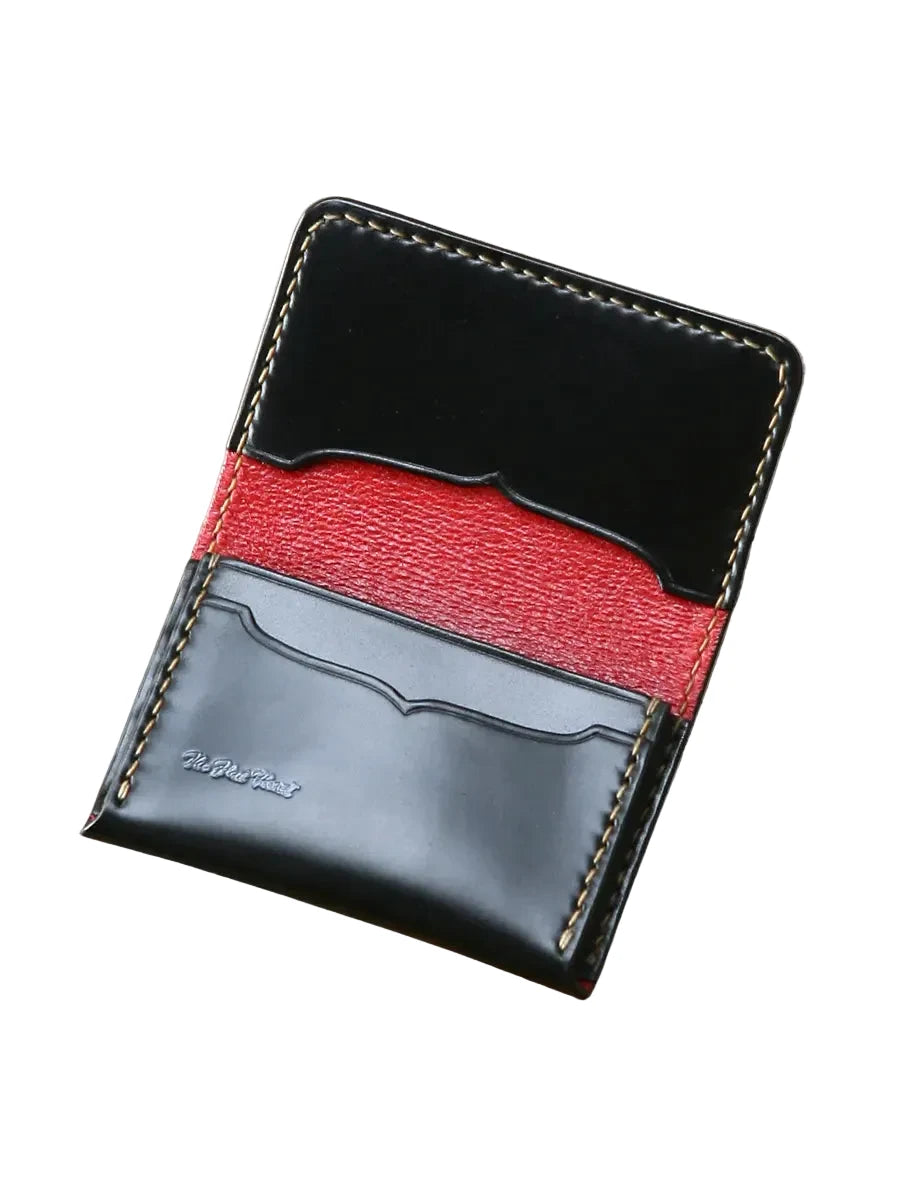 Black and red leather wallet on a wooden surface