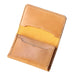 A slim tan leather card holder wallet with multiple card slots, shown open on a rustic gray wooden plank background.