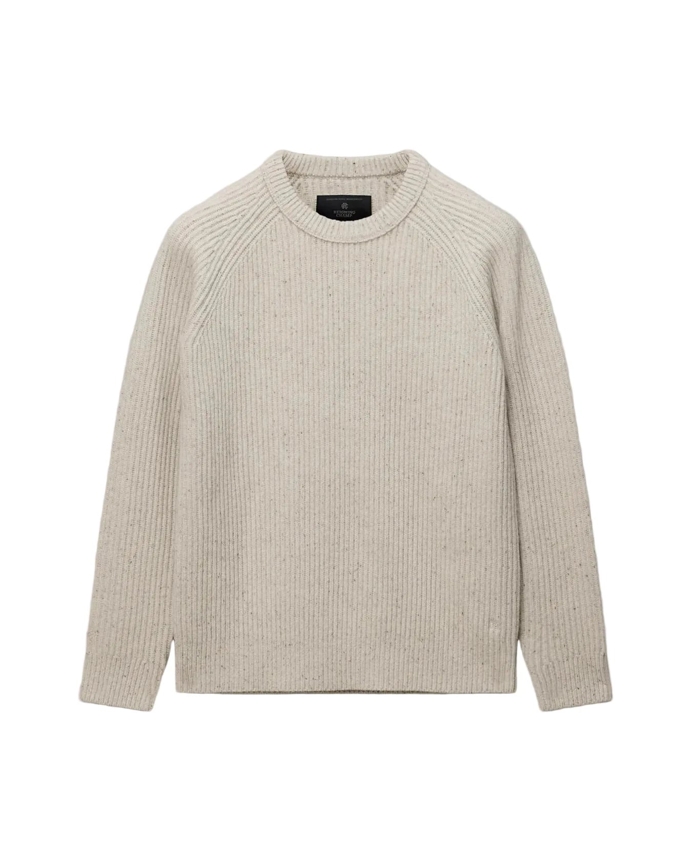 A light beige ribbed knit crewneck sweater with long sleeves, laid flat against a light gray background.