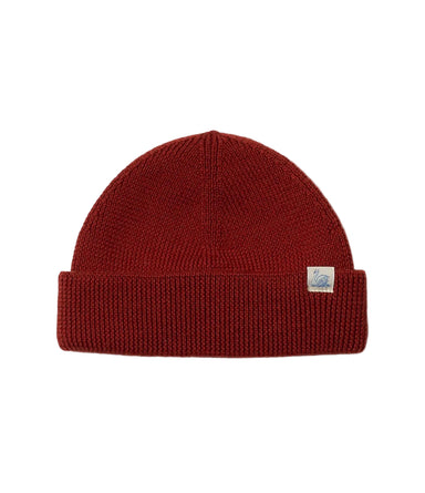 Red knit beanie with a brand label on a light gray background