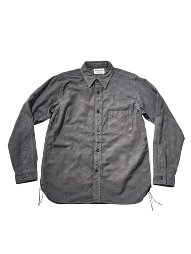 A dark gray, long-sleeve button-up shirt with a chest pocket, laid flat against a light gray background.