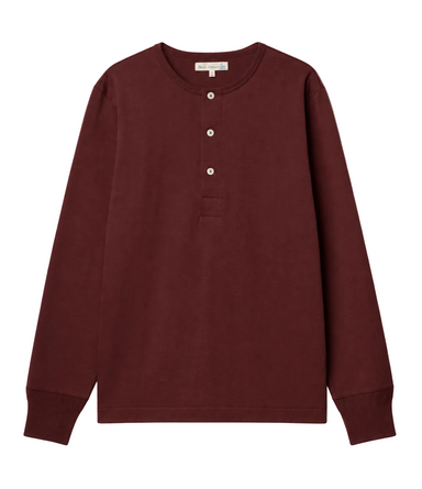 A dark burgundy long-sleeve henley shirt with a three-button placket and a small chest pocket, displayed flat against a light off-white background.