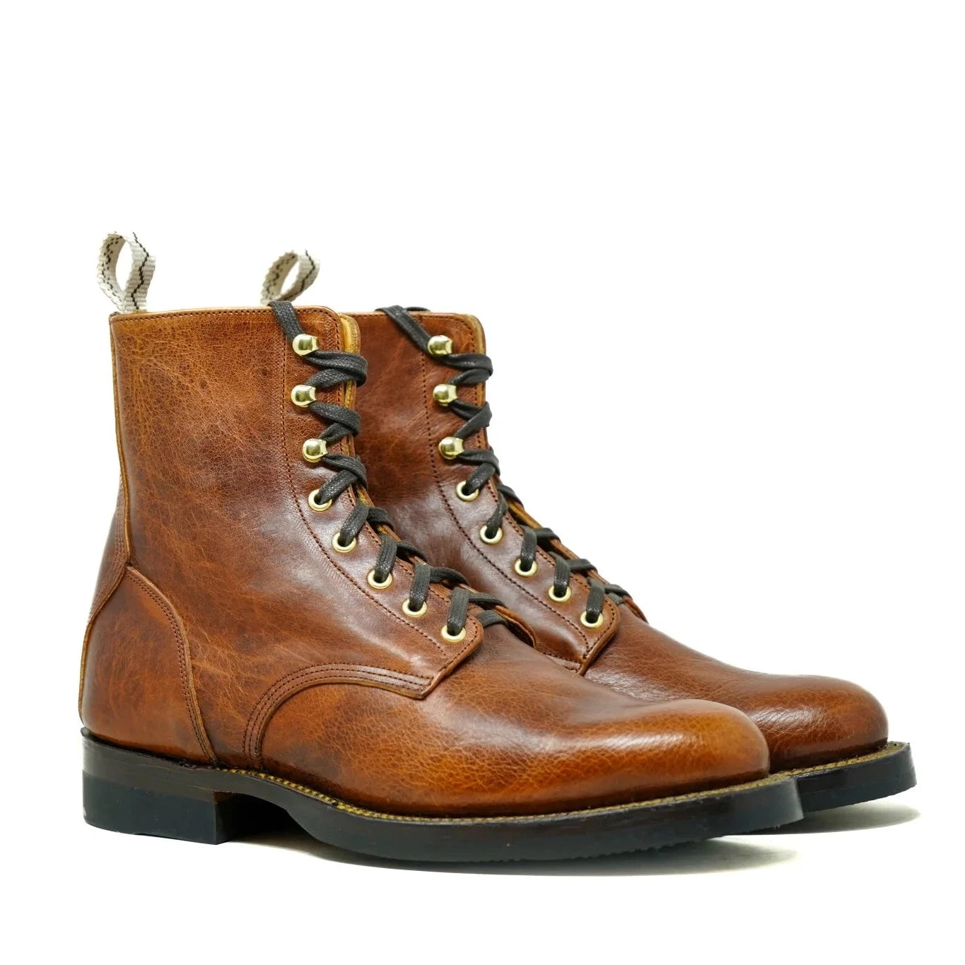 Pair of brown leather boots with gold laces on a white background