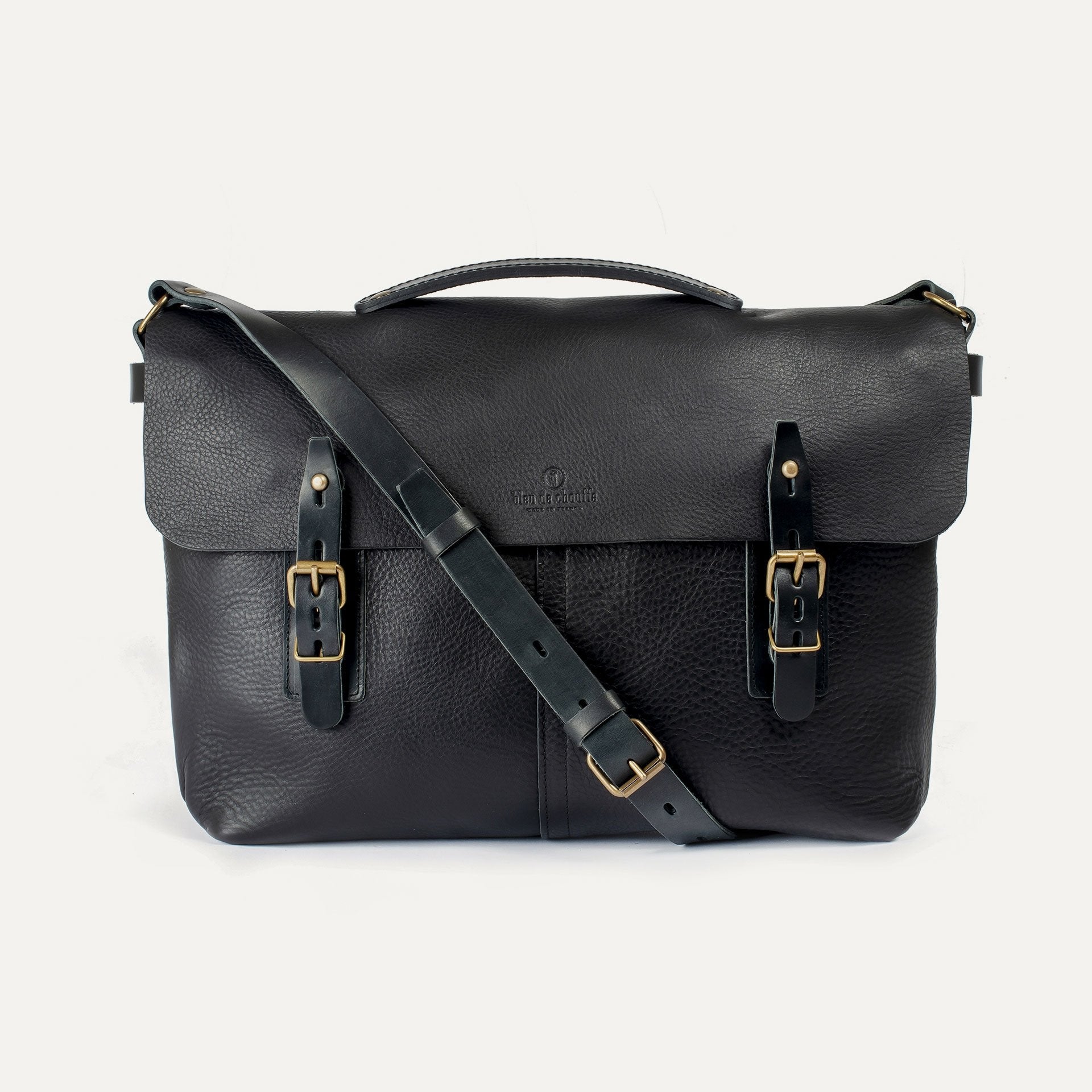 Black leather satchel bag with gold buckles on a white background