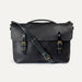 Black leather satchel bag with gold buckles on a white background