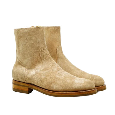 Pair of beige suede boots on a white background