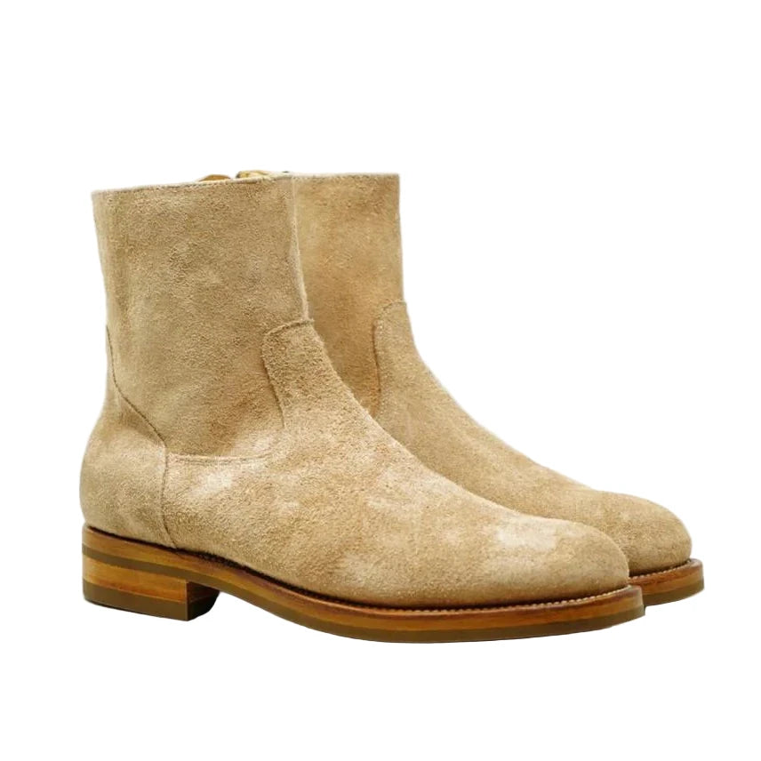 Pair of beige suede boots on a white background