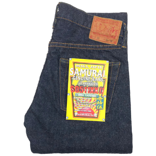 Folded denim jeans with a Samurai Jeans label on a white background